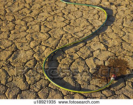 Garden hose on dry earth View Large Photo Image Stock Photography - Garden hose on dry earth. Fotosearch