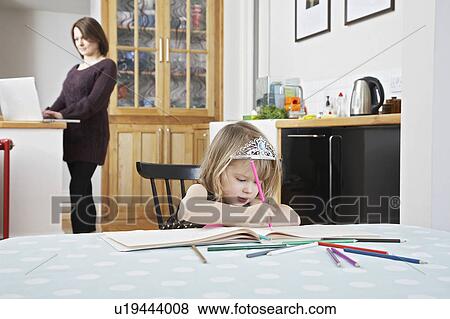 Girl (3-4) drawing in book, mother using laptop in background View Large Photo Image Stock Photo - Girl (3-4) drawing in book, mother using laptop in background. Fotosearch