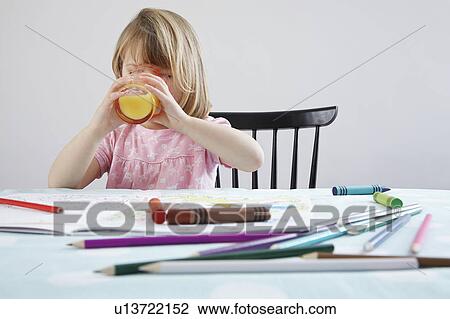 Girl (3-4) drinking orange juice, crayons in foreground View Large Photo Image Stock Image - Girl (3-4) drinking orange juice, crayons in foreground. Fotosearch