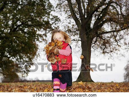 Girl (3-4) playing in autumn leaves View Large Photo Image Stock Image - Girl (3-4) playing in autumn leaves. Fotosearch
