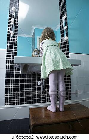 Girl (3-4) standing on wooden chest to reach bathroom sink View Large Photo Image Stock Image - Girl (3-4) standing on wooden chest to reach bathroom sink. Fotosearch