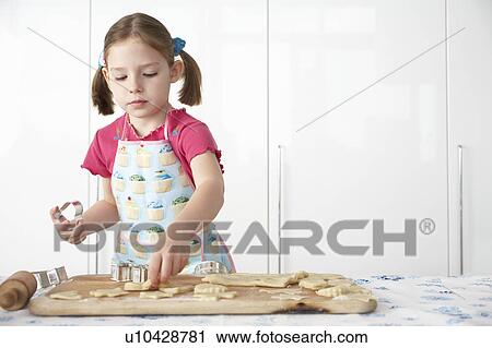 Girl (5-6) cutting dough on board in kitchen View Large Photo Image Stock Image - Girl (5-6) cutting dough on board in kitchen. Fotosearch