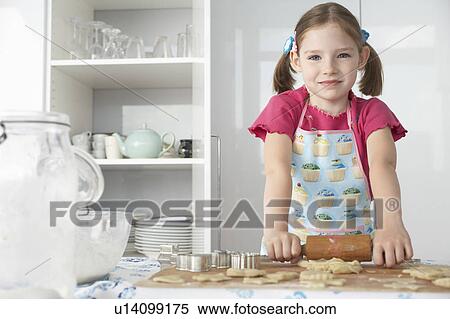 Girl (5-6) rolling dough in kitchen, portrait View Large Photo Image Stock Photography - Girl (5-6) rolling dough in kitchen, portrait. Fotosearch