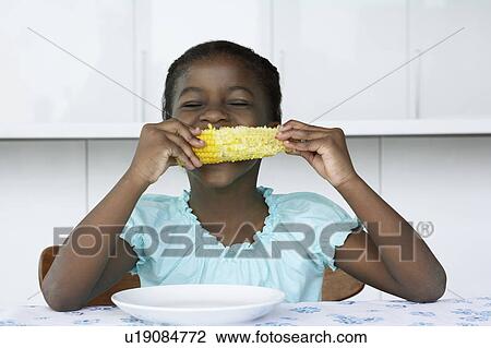 Girl (5-6) sitting at table, eating corn cobb View Large Photo Image Stock Image - Girl (5-6) sitting at table, eating corn cobb. Fotosearch