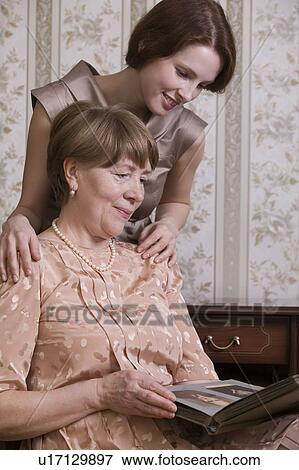 Grandmother and grand-daughter look at photograph album together View Large Photo Image Stock Photo - Grandmother and grand-daughter look at photograph album together. Fotosearch