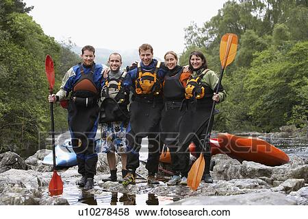 Stock Photo - Group of people with kayaks by river, portrait. Fotosearch
