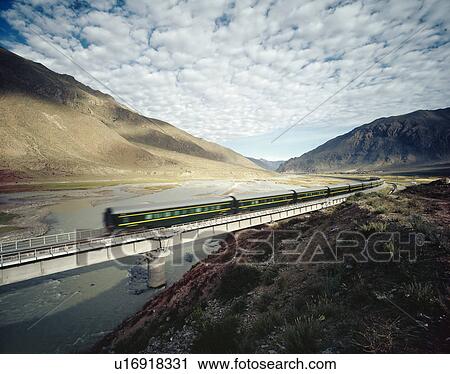 Stock Image - High Speed Train Traveling Through Valley. Fotosearch