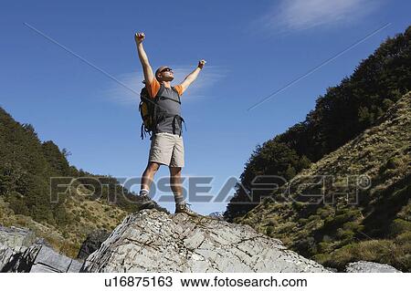 Hiker with arms outstretched on rock in river View Large Photo Image Stock Image - Hiker with arms outstretched on rock in river. Fotosearch