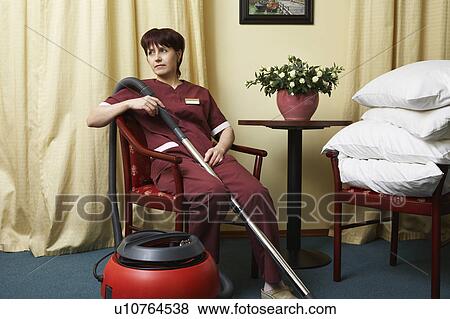 Stock Photo - Hotel Housekeeper Resting in Chair. Fotosearch