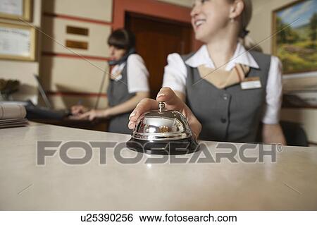 Stock Photograph - Hotel Receptionist Ringing Service Bell. Fotosearch