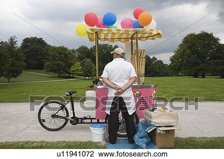 Stock Image - Ice Cream tricycle stand on footpath in public park. Fotosearch