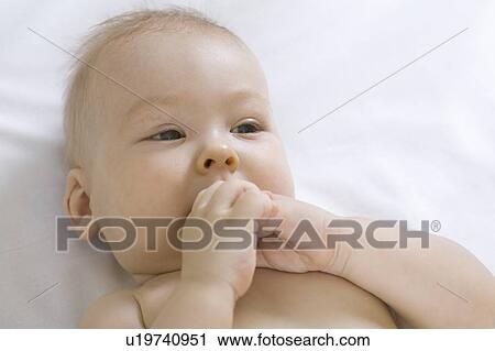Infant child chewing fists View Large Photo Image Stock Image - Infant child chewing fists. Fotosearch
