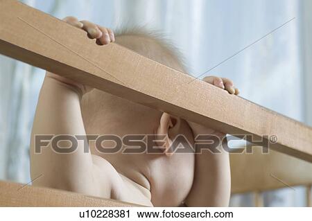 Infant child stands in cot View Large Photo Image Stock Image - Infant child stands in cot. Fotosearch