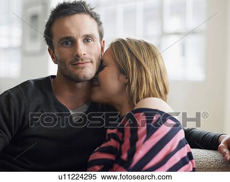 Stock Photography - Intimate young couple on couch, (portrait). Fotosearch