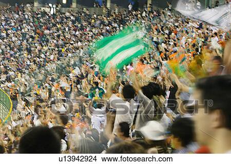 Picture - Japan, Kobe, Yahoo Stadium, crowd of people watching baseball match, motion blur. Fotosearch