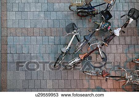 Stock Image - Japan, Tokyo, Ueno JR Station, man passing bicycles, view from above, motion blur. Fotosearch