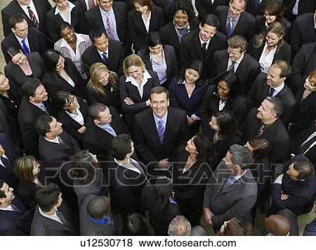 Large group of business people surrounding man looking up, elevated view View Large Photo Image Stock Photo - Large group of business people surrounding man looking up, elevated view. Fotosearch