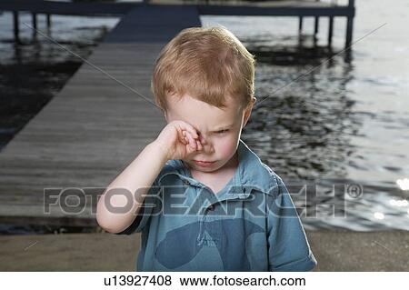 Stock Photo - Little Boy on Pier Rubbing His Eyes. Fotosearch