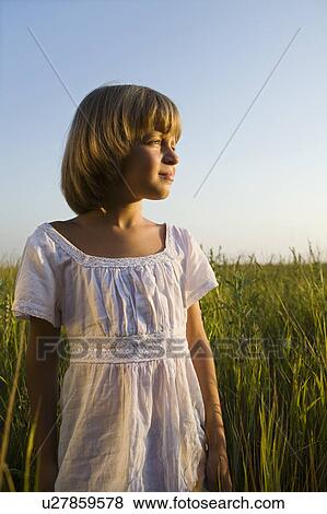 Stock Photo - Little Girl Standing in a Field. Fotosearch