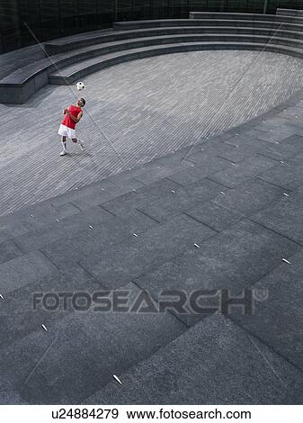 Man bouncing soccer ball off chest in the Scoop amphitheatre, London, England, elevated view View Large Photo Image Stock Photo - Man bouncing soccer ball off chest in the Scoop amphitheatre, London, England, elevated view. Fotosearch