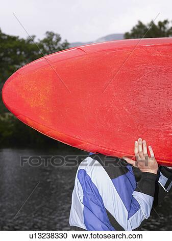 Man carrying kayak outdoors View Large Photo Image Stock Image - Man carrying kayak outdoors. Fotosearch
