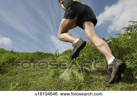 Stock Photograph - Man hiking in countryside, low section. Fotosearch