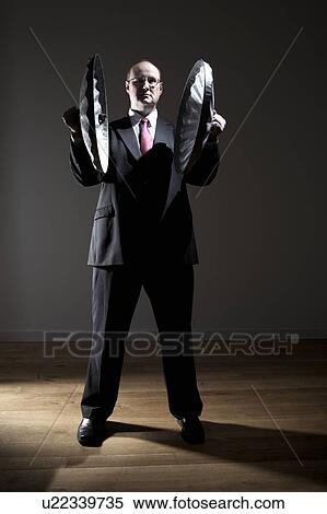 Man in full suit holding two garbage can lids View Large Photo Image Stock Photography - Man in full suit holding two garbage can lids. Fotosearch