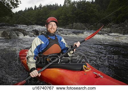 Stock Photo - Man kayaking in river, portrait. Fotosearch