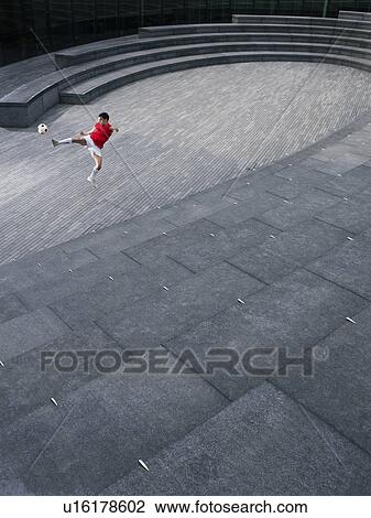 Man kicking soccer ball in the Scoop amphitheatre, London, England, elevated view View Large Photo Image Stock Image - Man kicking soccer ball in the Scoop amphitheatre, London, England, elevated view. Fotosearch