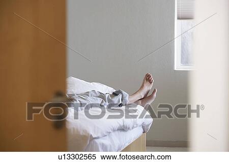 Man lying across bed, low section View Large Photo Image Stock Photography - Man lying across bed, low section. Fotosearch