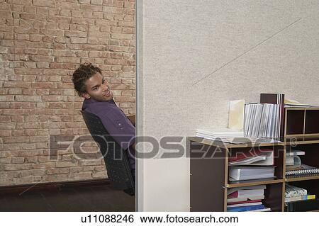 Stock Photograph - Man peering around corner in office. Fotosearch