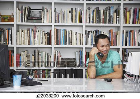 Stock Image - Man Phoning in Home Office. Fotosearch