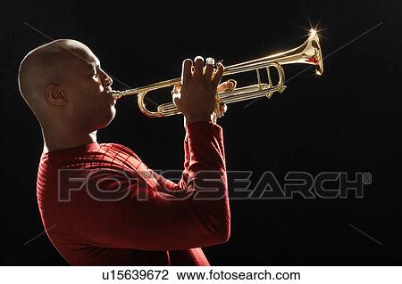 Stock Image - Man Playing Trumpet, close-up, side view. Fotosearch