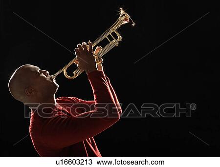 Stock Image - Man Playing Trumpet, side view, close-up. Fotosearch