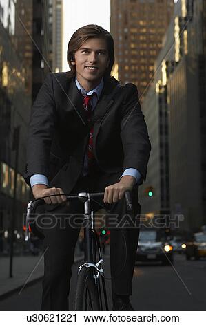 Man riding bicycle on street View Large Photo Image Stock Image - Man riding bicycle on street. Fotosearch