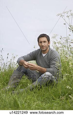 Man sitting in field, portrait View Large Photo Image Stock Photo - Man sitting in field, portrait. Fotosearch
