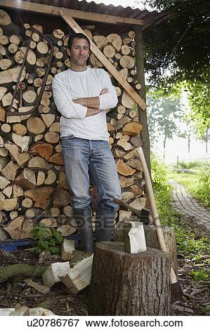 Man standing beside axe at timber shed, portrait View Large Photo Image Stock Photo - Man standing beside axe at timber shed, portrait. Fotosearch
