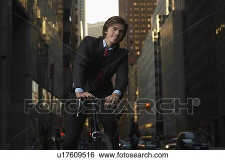 Man standing by bicycle in street, portrait View Large Photo Image Stock Photograph - Man standing by bicycle in street, portrait. Fotosearch