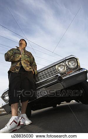 Man standing in front of car, low angle view View Large Photo Image Stock Image - Man standing in front of car, low angle view. Fotosearch