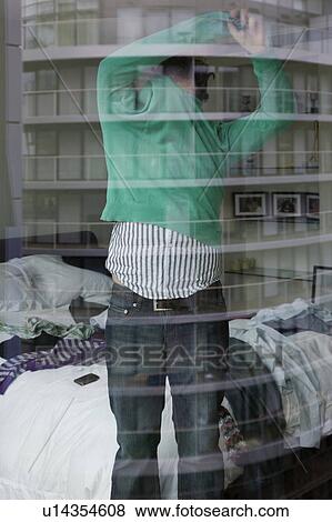 Man undressing in bedroom, view through window View Large Photo Image Stock Photo - Man undressing in bedroom, view through window. Fotosearch