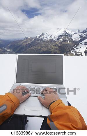 Man using laptop on snowy mountain peak, close up of hands View Large Photo Image Stock Photo - Man using laptop on snowy mountain peak, close up of hands. Fotosearch