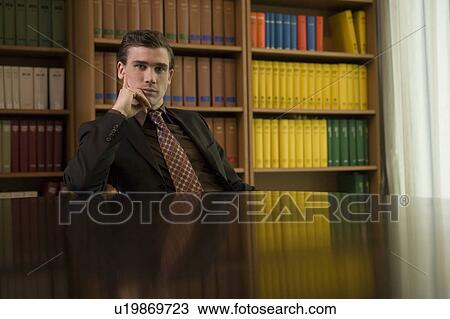 Man wearing suit at desk in library, portrait View Large Photo Image Stock Image - Man wearing suit at desk in library, portrait. Fotosearch