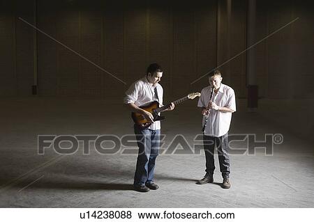 Stock Photo - Men practising electric guitar and the clarinet. Fotosearch