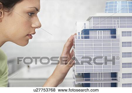 Mid adult woman inspecting architectural model, profile, close-up View Large Photo Image Stock Photo - Mid adult woman inspecting architectural model, profile, close-up. Fotosearch