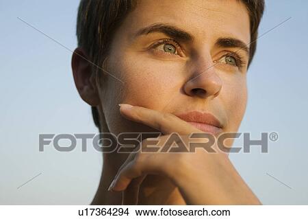 Mid-adult woman looking away, close-up view View Large Photo Image Picture - Mid-adult woman looking away, close-up view. Fotosearch