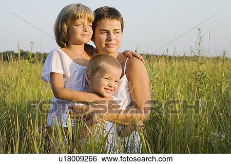 Stock Photograph - Mother and Children in a Field of Grass. Fotosearch