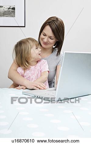Mother and daughter (3-4) sitting beside laptop View Large Photo Image Stock Image - Mother and daughter (3-4) sitting beside laptop. Fotosearch