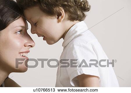 Stock Image - Mother and son face to face, smiling. Fotosearch