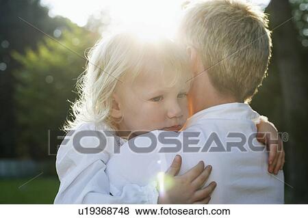 Stock Photo - Mother carrying daughter (3-4) in garden. Fotosearch