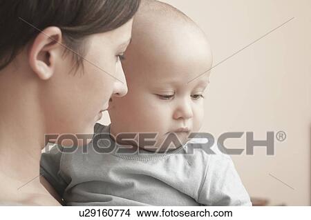 Picture - Mother holds serious toddler. Fotosearch